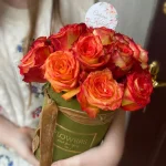 Jesienny box pełn ciepłych barw. Pomarańczowo-żółte róże w pastelowym pudełku, przewiązane aksamitną wstążką, tworzą harmonijną całość.