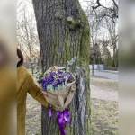Wiązanka z eustomy, gipsówki i eukaliptusa w retro stylu, ozdobiona bibułą przypominającą stare gazety i fioletową kokardą – wyjątkowa i elegancka kompozycja.