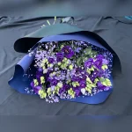 Elegancki bukiet kondolencyjny w niebieskiej tonacji z eustomą, gipsówką, czarną bibułą i dużą kokardą