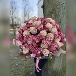 Bukiet w odcieniach różu z gipsówką, goździkami i kremowo-różowymi różami zachwyca elegancją. Subtelna bibuła podkreśla pastelową harmonię tej wyjątkowej kompozycji.